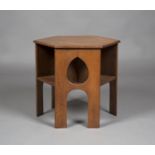 An early 20th century Arts and Crafts oak hexagonal book table, three sides pierced with teardrop