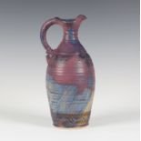 An Irish Michael Kennedy Pottery stoneware jug, the gently ribbed ovoid body covered in a purple