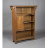 An Edwardian Arts and Crafts oak open bookcase, the moulded top above pierced bracket supports,
