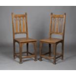 A pair of Edwardian Arts and Crafts oak side chairs by Shapland & Petter of Barnstaple, the triple