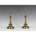 A pair of late 19th century Arts and Crafts brass three-light candelabra, the scrollwork branches