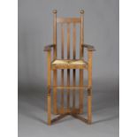 A late 19th/early 20th century Arts and Crafts oak framed child's high chair, in the manner of