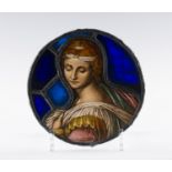 A Renaissance style stained and leaded glass circular portrait panel, depicting the head and