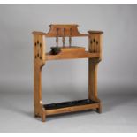 An Edwardian Arts and Crafts oak hallstand, in the manner of Liberty & Co, the back and sides with