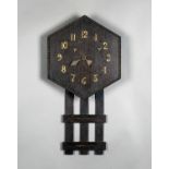 An Arts and Crafts oak wall clock with eight-day chiming movement, the hexagonal dial with applied