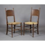 A set of six early 20th century Arts and Crafts oak and ash framed panel back dining chairs by