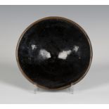 A tenmoku glazed studio pottery bowl, probably by Richard Batterham, of flared circular shape on a