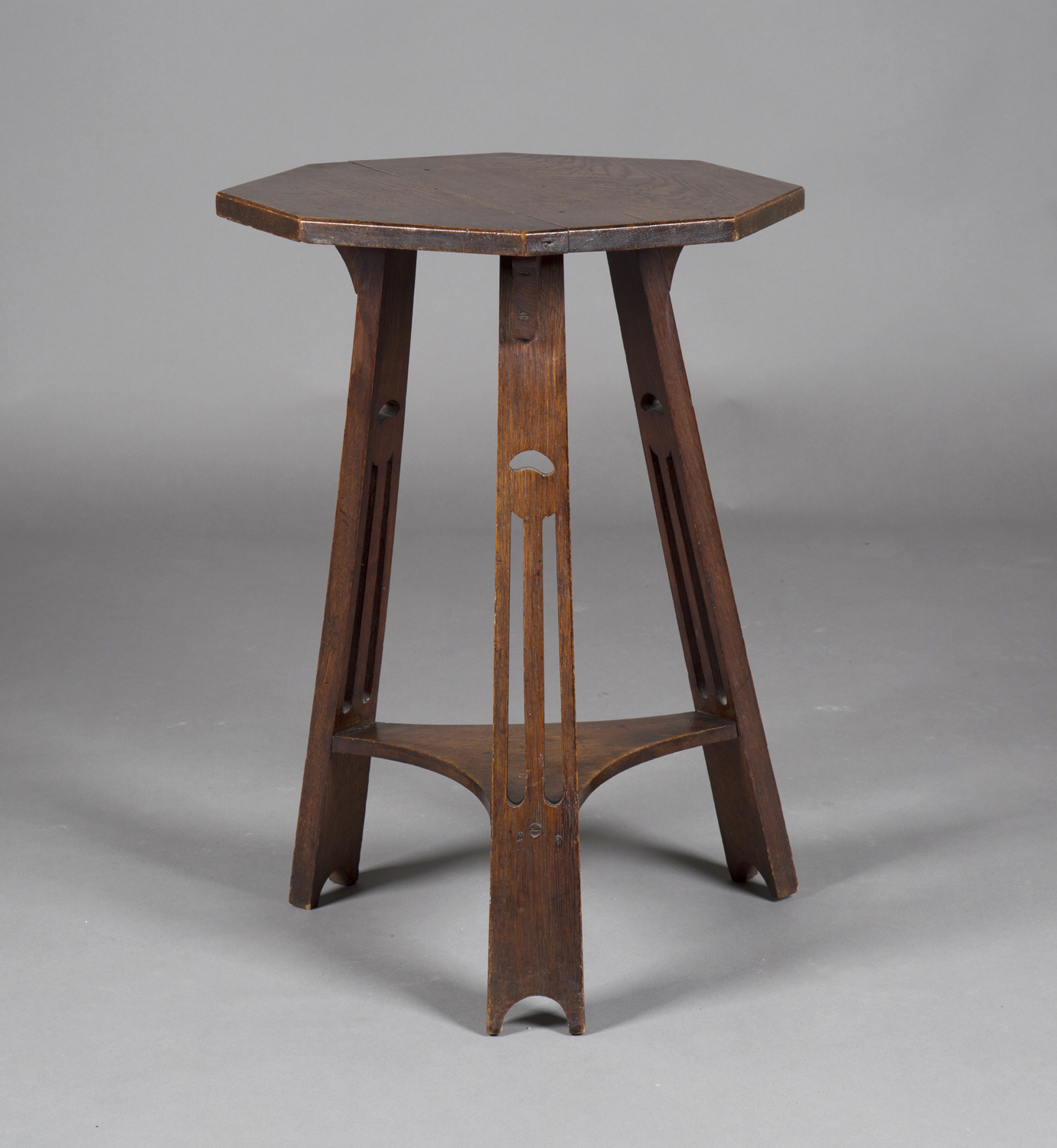An Edwardian Arts and Crafts oak octagonal two-tier occasional table, probably by Liberty & Co,