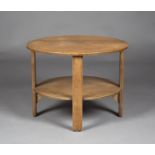 An early 20th century oak circular two-tier occasional table, in the manner of Heals, raised on