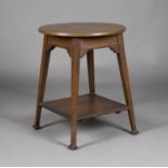 An Edwardian Arts and Crafts oak framed circular occasional table, the patinated copper top above