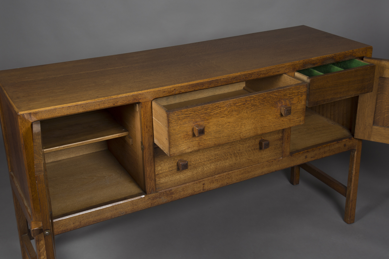 An early 20th century oak sideboard by Heals, the chamfered top above two drawers flanked by - Image 2 of 2