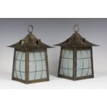 A pair of early 20th century Arts and Crafts Glasgow School anodized brass hall lanterns, the hooded
