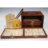 A Chinese Mahjong set, early 20th century, with bone and bamboo tiles, contained within a five