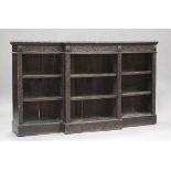 A late Victorian stained oak breakfront open bookcase with overall carved foliate decoration, height