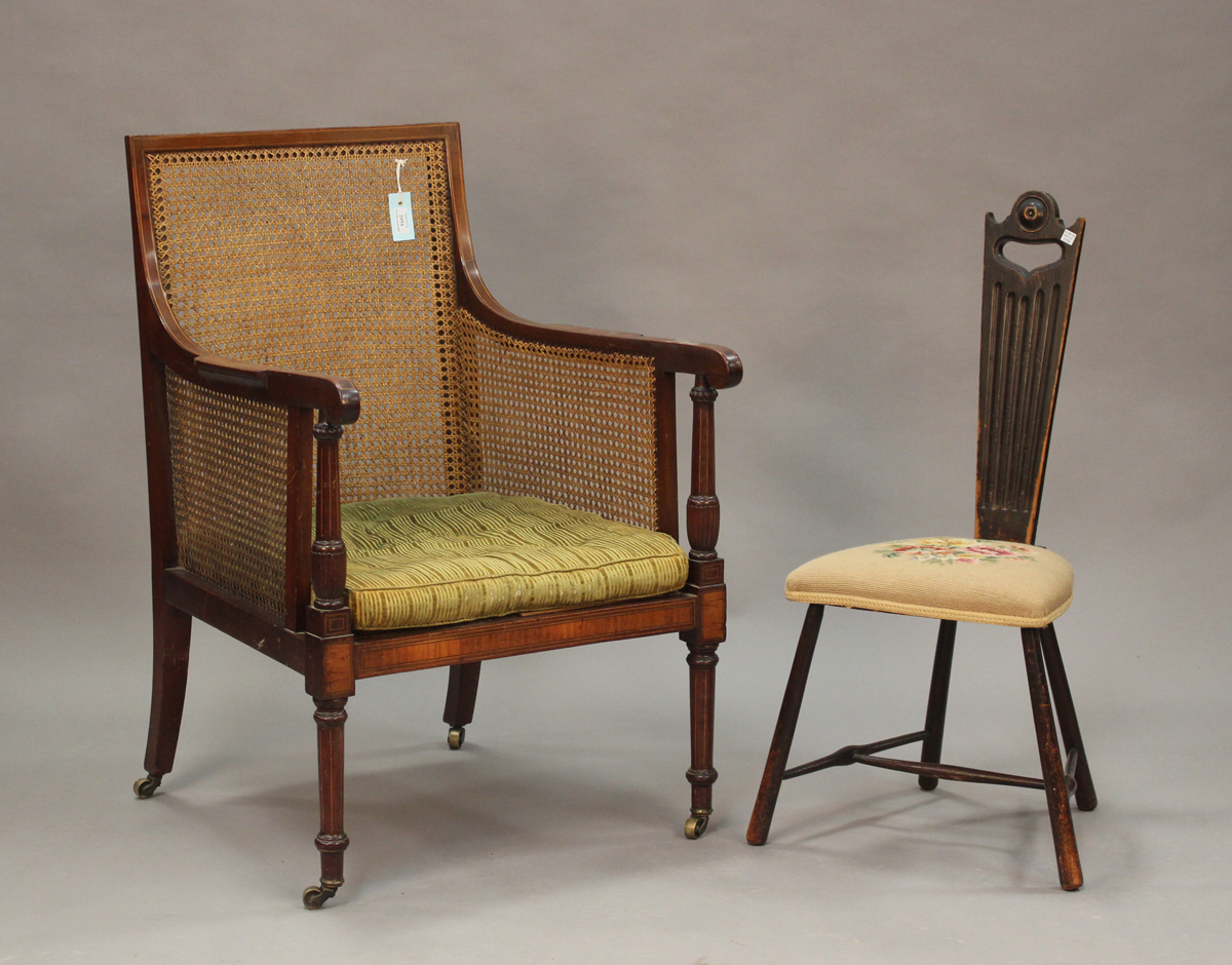 An Edwardian mahogany bergère library armchair, the caned seat, back and side panels within a