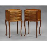 A pair of late 20th century French cherry bedside tables, the galleried tops above three drawers, on