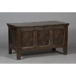 A late 17th century oak panelled coffer, the two-piece plank top with notched edges, the triple-