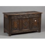 A late 20th century Carolean style panelled oak coffer, the front carved with lunettes and arches,