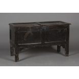 An early 18th century oak panelled coffer, the hinged lid with wrought iron latch, raised on long