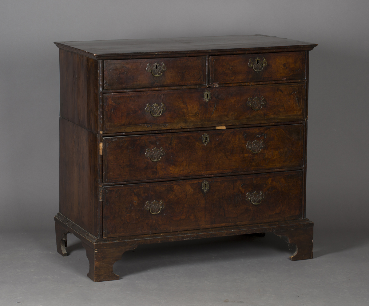 A George I walnut chest of two short and three long drawers with feather and crossbanded borders,