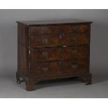 A George I walnut chest of two short and three long drawers with feather and crossbanded borders,