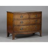 A Regency mahogany bowfront chest of two short and two long drawers, the front with 'plum pudding'