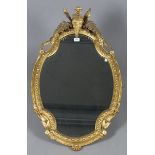 A late Victorian gilt composition shaped oval wall mirror, the fern frond surmount above an ovolo
