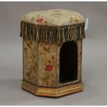 A mid-Victorian needlework box seat stool of canted square form, one side with open arch to form a