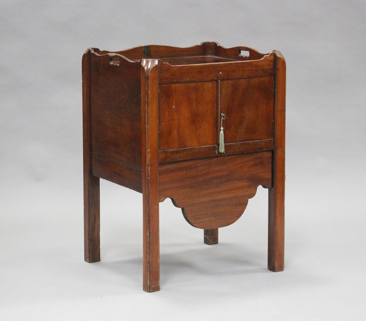 An early 19th century mahogany night cupboard, the galleried top above a pair of doors and a drawer,