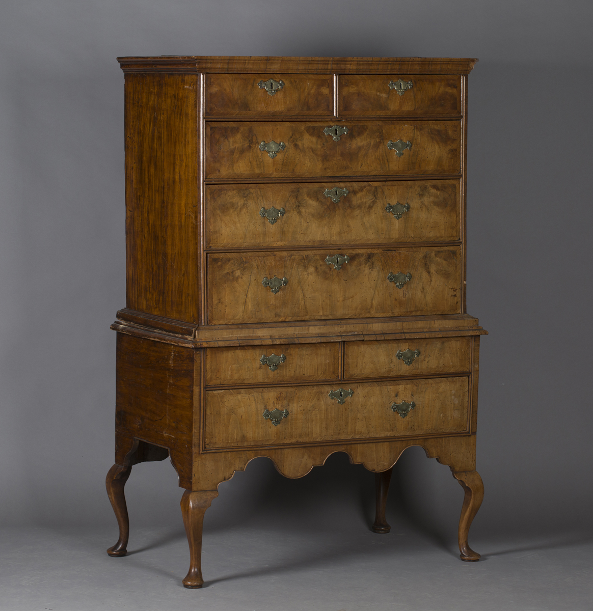 A George I walnut chest-on-stand, the moulded pediment above two short and three long oak-lined