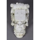 A 19th century cast plaster architectural corbel of scrolling form, the heraldic shield above a