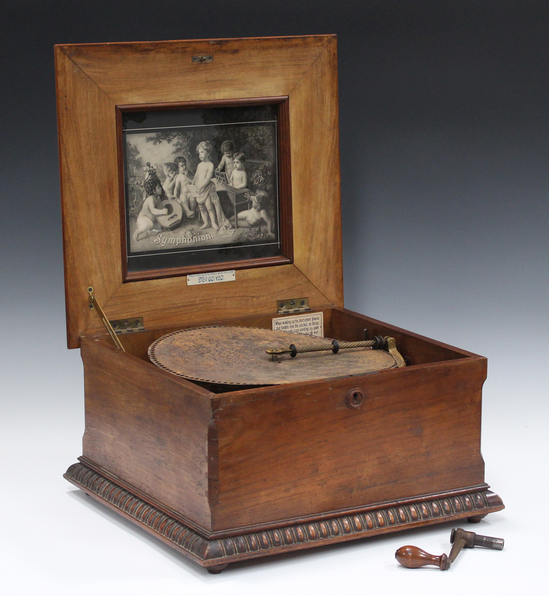 A late 19th century walnut cased Symphonium, playing 33.5cm discs, the hinged lid with transfer