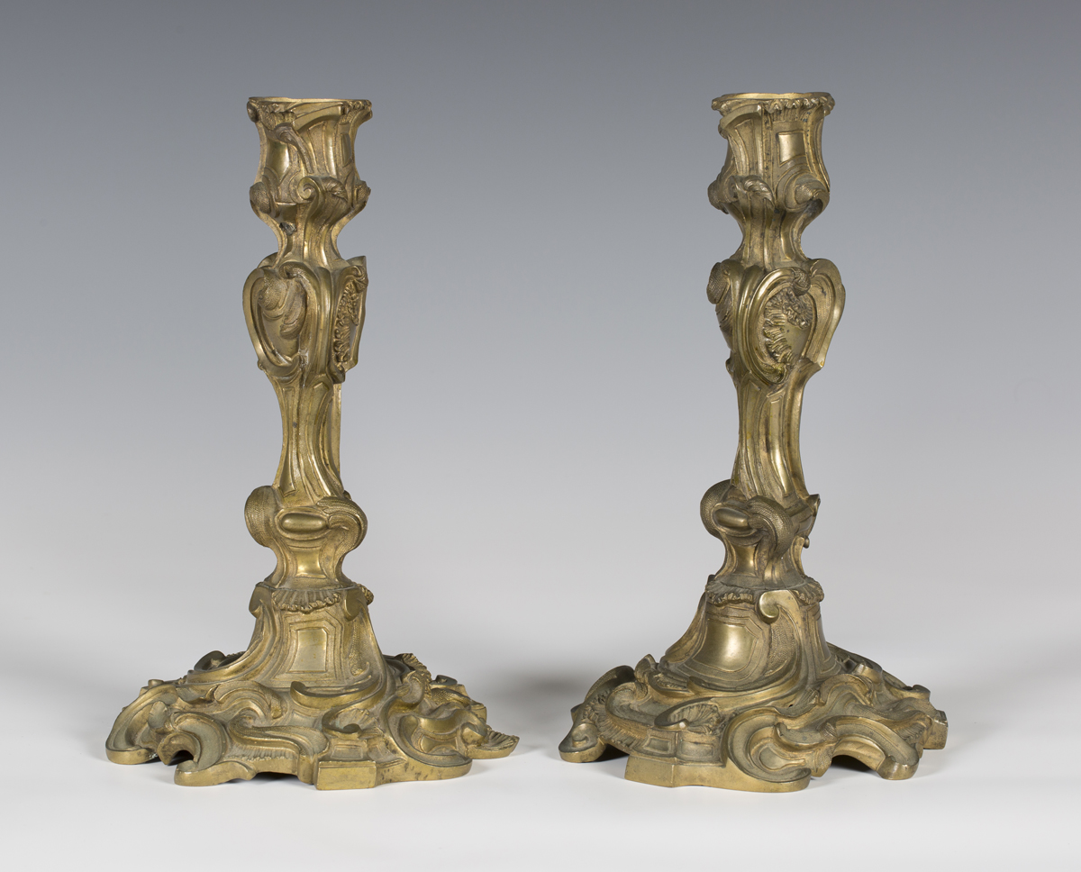 A pair of Rococo gilt bronze candlesticks of foliate scrolling form, height 28cm (lacking sconces).