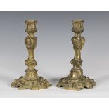 A pair of Rococo gilt bronze candlesticks of foliate scrolling form, height 28cm (lacking sconces).