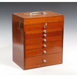 A mid-20th century mahogany dentist's equipment cabinet, fitted with a hinged lid above six drawers,