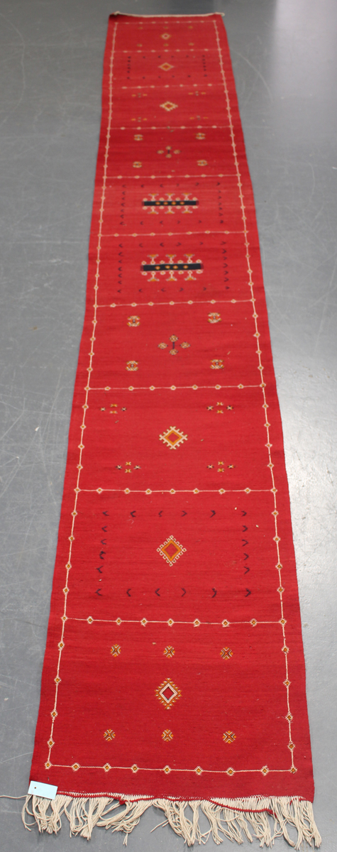 An Afghan kelhim runner, late 20th century, the claret field sparsely decorated with stylized