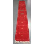 An Afghan kelhim runner, late 20th century, the claret field sparsely decorated with stylized