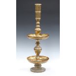 A 20th century Middle Eastern brass candlestick, the baluster stem and two circular pans engraved