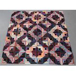 An early 20th century silk patchwork quilt, worked with overall geometric squares, 184cm x 181cm.