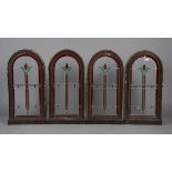 A set of four 20th century leaded and stained glass arched window panels within oak frames, height