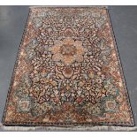 A Turkish part silk rug, late 20th century, the midnight blue field with a flowerhead medallion,