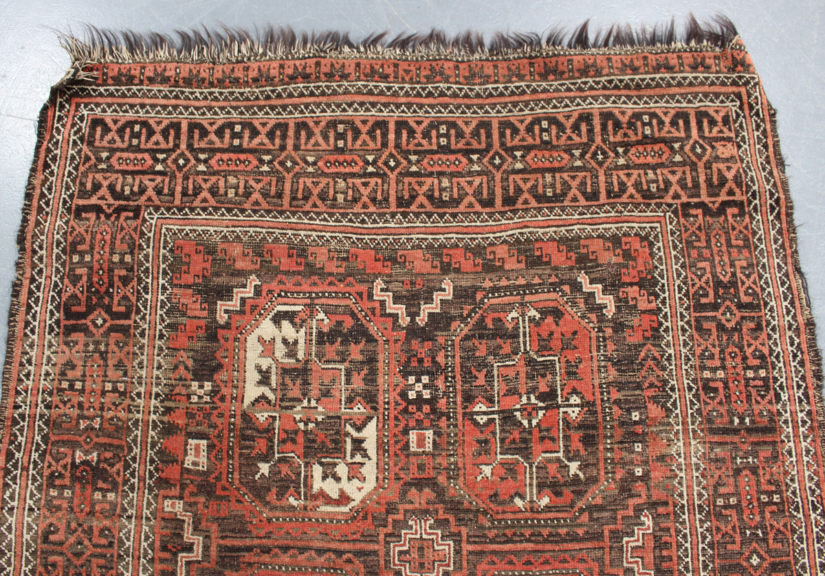 A Beluche rug, Afghan/Persian borders, early 20th century, the red field with six medallions, within - Image 4 of 4