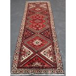 A Hamadan runner, North-west Persia, mid-20th century, the red field with a single column of stepped