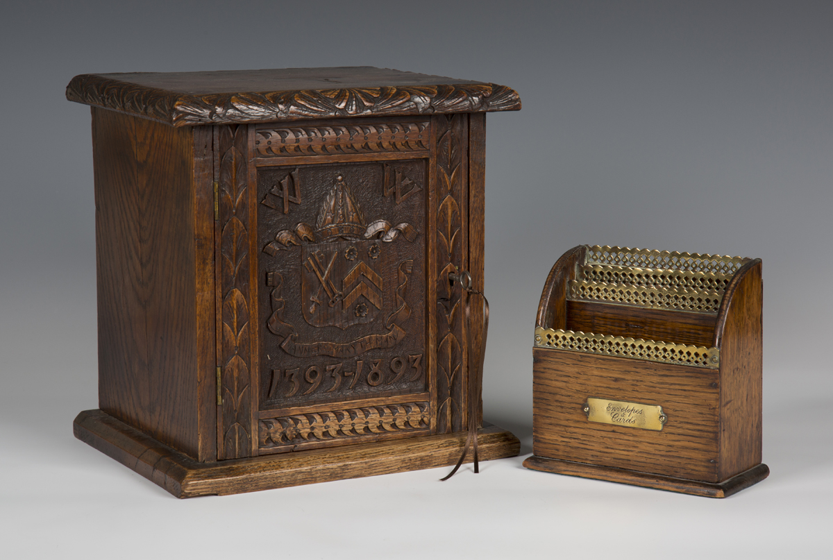 A late Victorian carved oak table-top box, the door carved with heraldic crest above dates '1393-