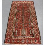 An Afghan rug, early 20th century, the red field with an overall ascending stylized tree, within a