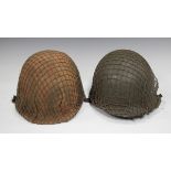 Two United States Army M1 pattern helmets, each with overall net covering, canvas lining and chin