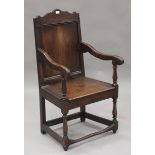 A 19th century oak Wainscot armchair, the panelled back above a solid seat, on turned and block