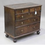 A Queen Anne provincial oak chest of drawers with applied brass pear shaped handles, raised on