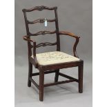 A George III mahogany pierced and carved ladder back elbow chair with drop-in needlework seat,