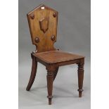 A mid-Victorian mahogany hall chair with a shield back and solid seat, on octagonal tapering legs,